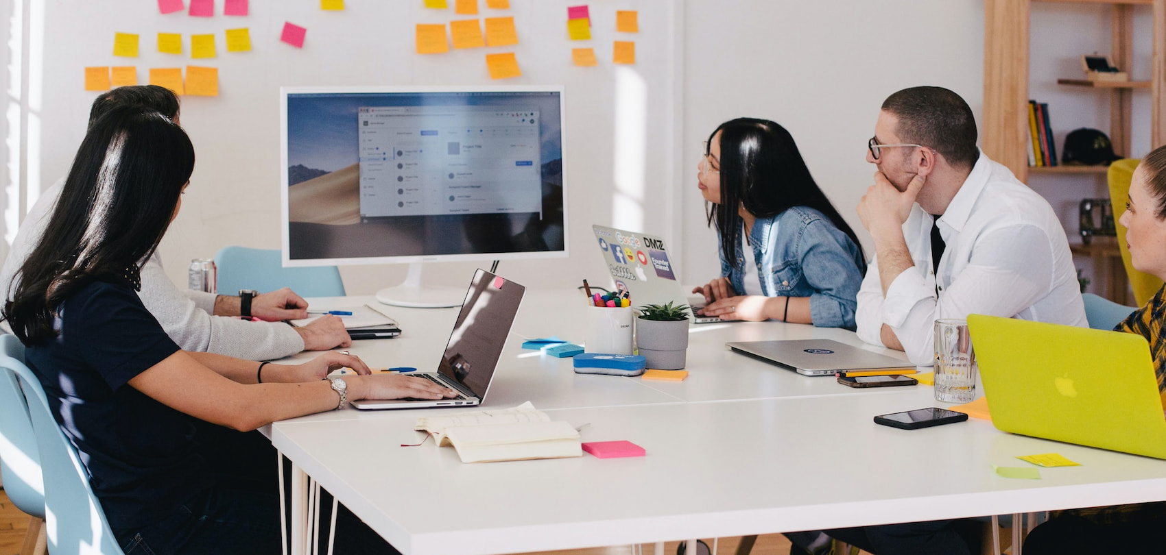 Smood employees in a meeting, talking around a table in a conference room.